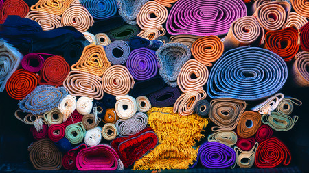 background of colorful carpets rolled and stackedの写真素材