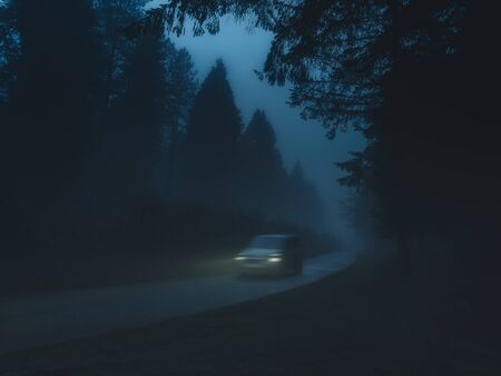 car in country road with fog and low visibility.
