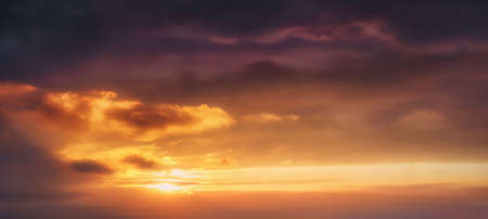 background of cloudscape at the sunset with sunshine on sky and orange cloudsの写真素材