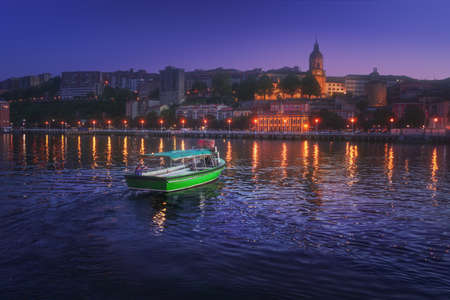 Portugalete city with boat transporting people at nightの写真素材