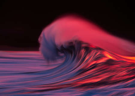 wave tube with spray breaking at sunset with in camera panning techniqueの写真素材