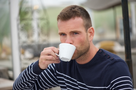 Young Man Drinking his Coffee at the Seasideの写真素材