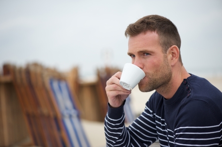 Man Drinking his Coffee at the Beachの写真素材