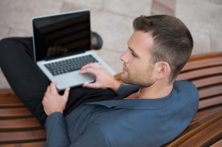 Man sitting in the city with a laptopの写真素材