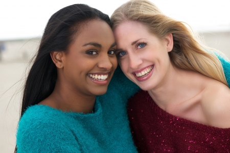 Multicultural friends laughing, smiling and hugging outdoors.の写真素材