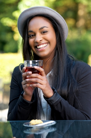 Smiling African Girl Drinking Tea Outdoorsの写真素材