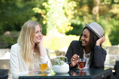 multicultural friends drinking tea outdoorsの写真素材