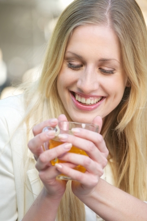 Young Blonde Girl Smiling with a Tea cupの写真素材