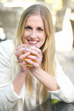 Young Blonde Girl Smiling and Holding her Tea Cupの写真素材