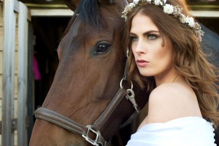 Beautiful caucasian fashion girl posing with her horseの写真素材