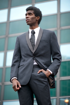 Portrait of an african american businessman standing outdoors in a black suitの写真素材