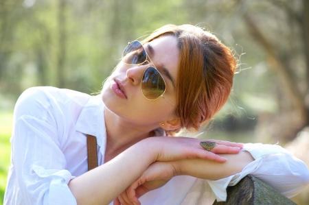 Portrait of a beautiful woman with sunglasses relaxing outdoorsの写真素材