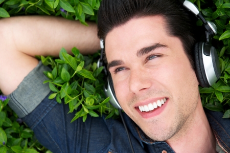 Close up portrait of a happy young man relaxing with headphonesの写真素材