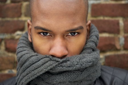 Close up portrait of a black male fashion model with gray scarf covering faceの写真素材