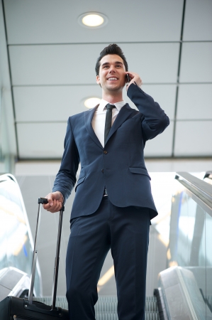 Portrait of a young businessman traveling with bag and phoneの写真素材