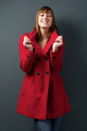 Portrait of a happy young woman smiling in red winter jacketの写真素材