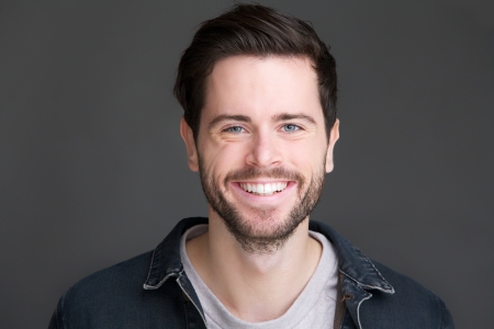 Closeup portrait of a smiling young man looking at camera Closeup portrait of a smiling young man looking at camera