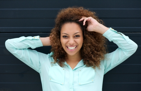 Closeup portrait of a happy young woman smiling outdoors against black backgroundの写真素材