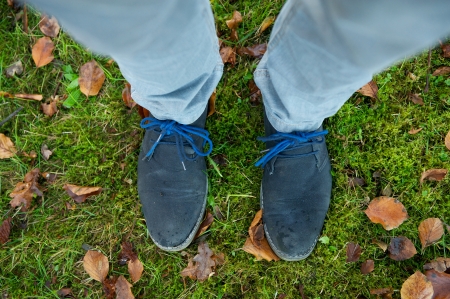 Two feet in boots standing on green grass outdoorsの写真素材