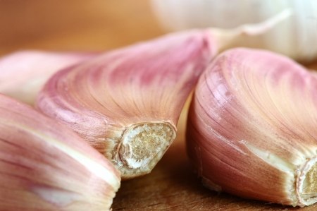 Close up group of fresh organic garlic on wooden cutting boardの写真素材