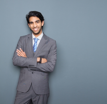 Close up portrait of a cheerful young businessman smiling against gray backgroundの写真素材