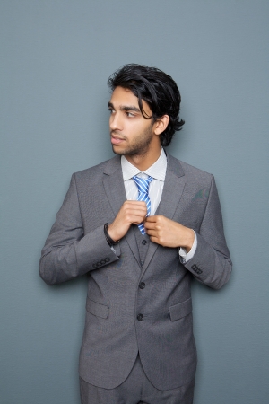 Portrait of a handsome young businessman standing against gray background の写真素材