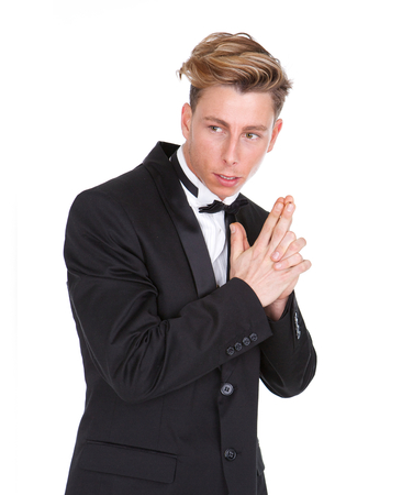 Portrait of a man in black tuxedo with gun hand gesture isolated on white backgroundの写真素材