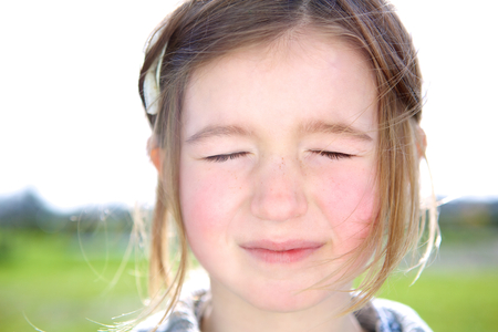 Close up portrait of a cute young girl with eyes closed thinking or imagining の写真素材