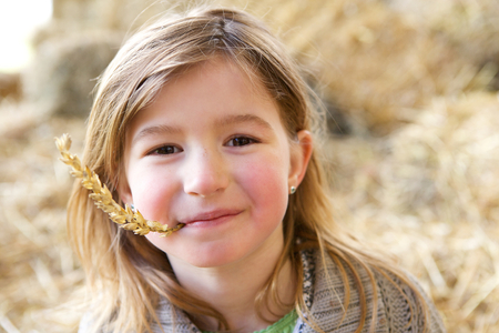 Close up portrait of a cute girl smiling with straw in mouthの写真素材