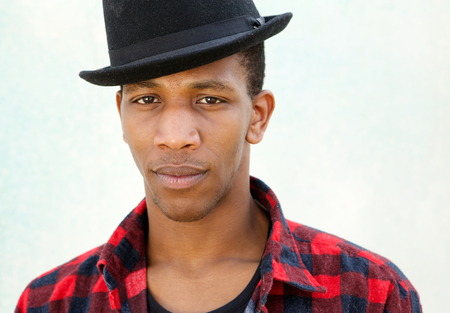 Close up portrait of a trendy young man with hat on white background
