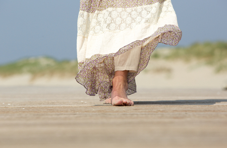 Low angle close up female feet walking forward at the beach の写真素材