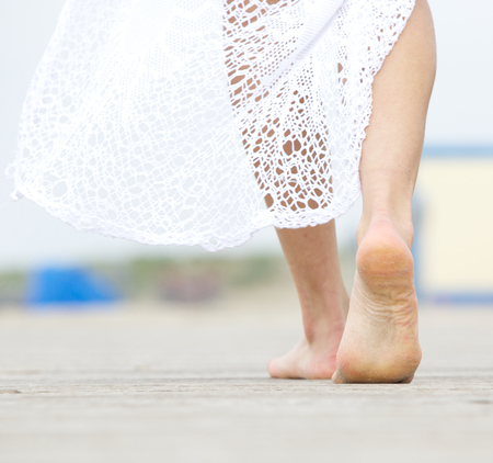 Close up portrait of a barefoot woman walking awayの写真素材