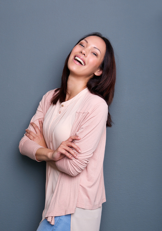 Portrait of a young asian female smiling with arms crossedの写真素材