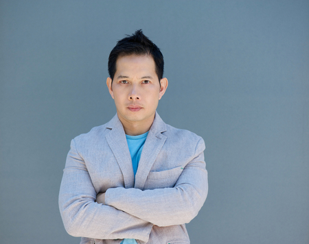 Portrait of a mature asian man posing with arms crossedの写真素材
