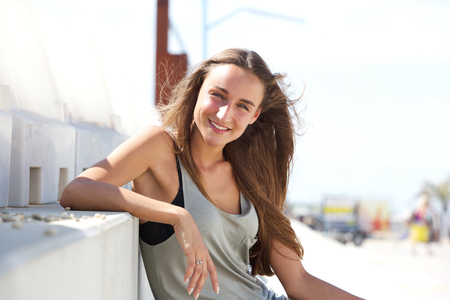 Close up portrait of a happy young woman sitting outsideの写真素材