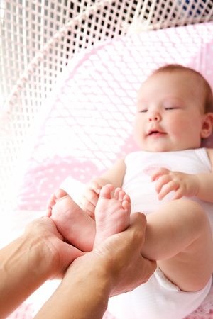 Close up portrait of a female hands holding baby feetの写真素材