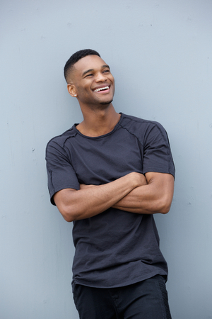 Portrait of a cheerful young man laughing with arms crossedの写真素材