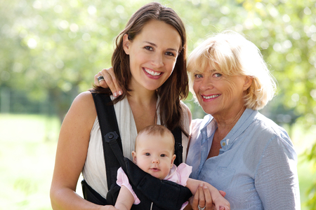 Close up portrait of a mother and grandmother smiling with baby