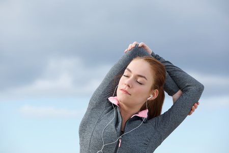 Close up portrait of a young woman stretching before workoutの写真素材