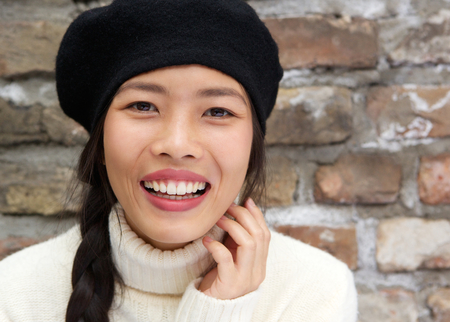 Close up portrait of a beautiful young asian woman smiling with hatの写真素材