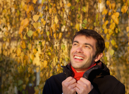 Close up portrait of a happy young man smiling outdoors with winter jacketの写真素材