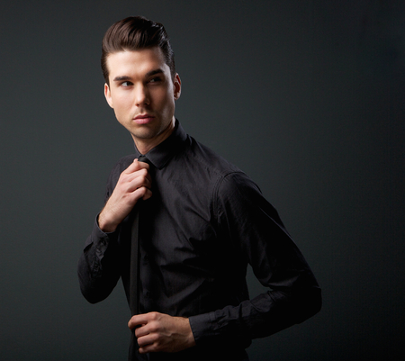 Close up portrait of a male fashion model in black shirt and tieの写真素材