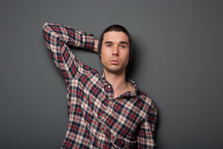 Close up portrait of a trendy young man in checkered shirt and hatの写真素材