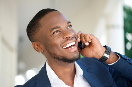 Close up portrait of a smiling young businessman calling by mobile phoneの写真素材