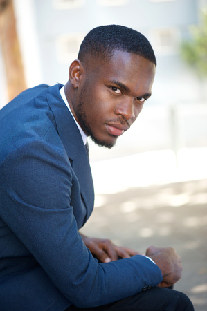 Side view portrait of a young african american businessman sitting outsideの写真素材
