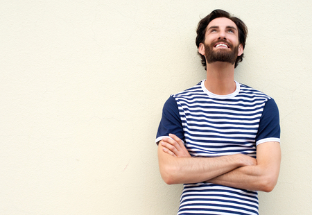 Portrait of a cheerful young man smiling and looking up on white backgroundの写真素材