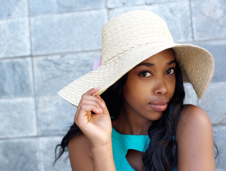 Close up portrait of a beautiful african american woman with sun hatの写真素材