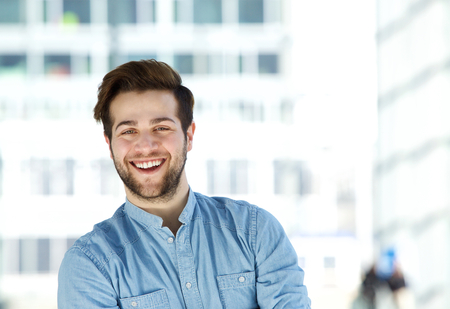 Close up portrait of an attractive modern young man with beard smilingの写真素材