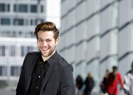 Close up portrait of a cool guy smiling in black business suit