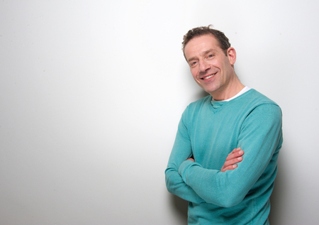 Portrait of a relaxed middle aged man smiling with arms crossed